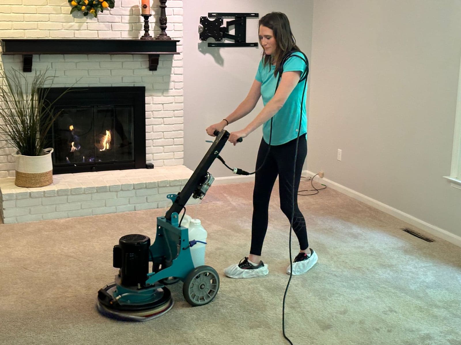 A B&G Carpet Cleaning technician running a low-moisture carpet machine in a living room