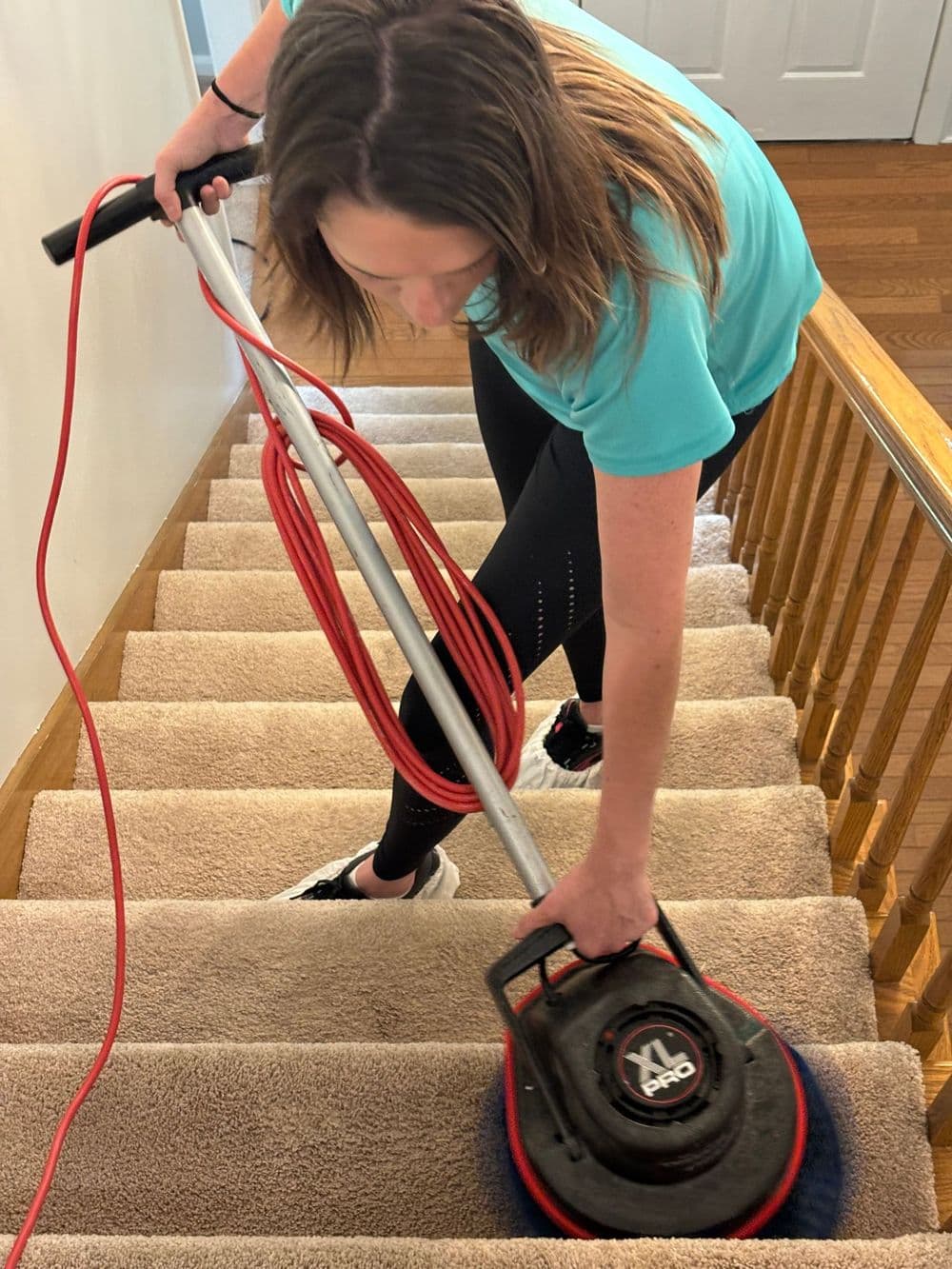 A B&G Carpet Cleaning technician cleaning carpeted stairs